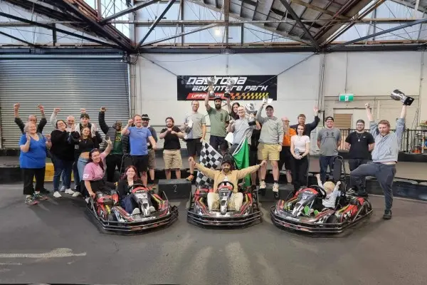A big group celebrating next to the karts