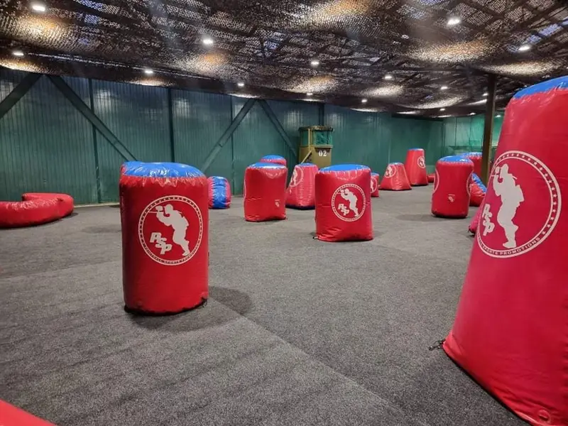 Netted indoor paintball field with inflatable bunkers